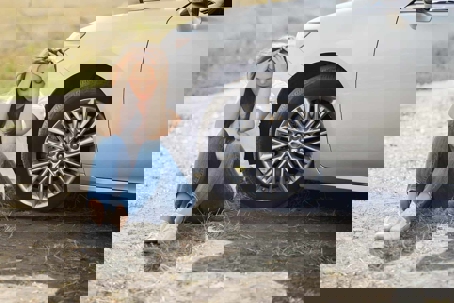 lady sitting upset by her car